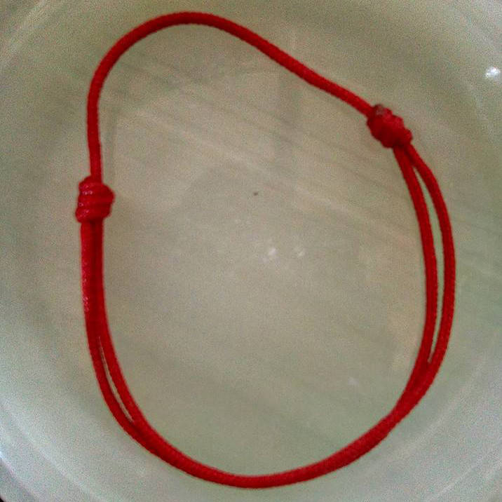 

Браслет "красная нить" на запястье