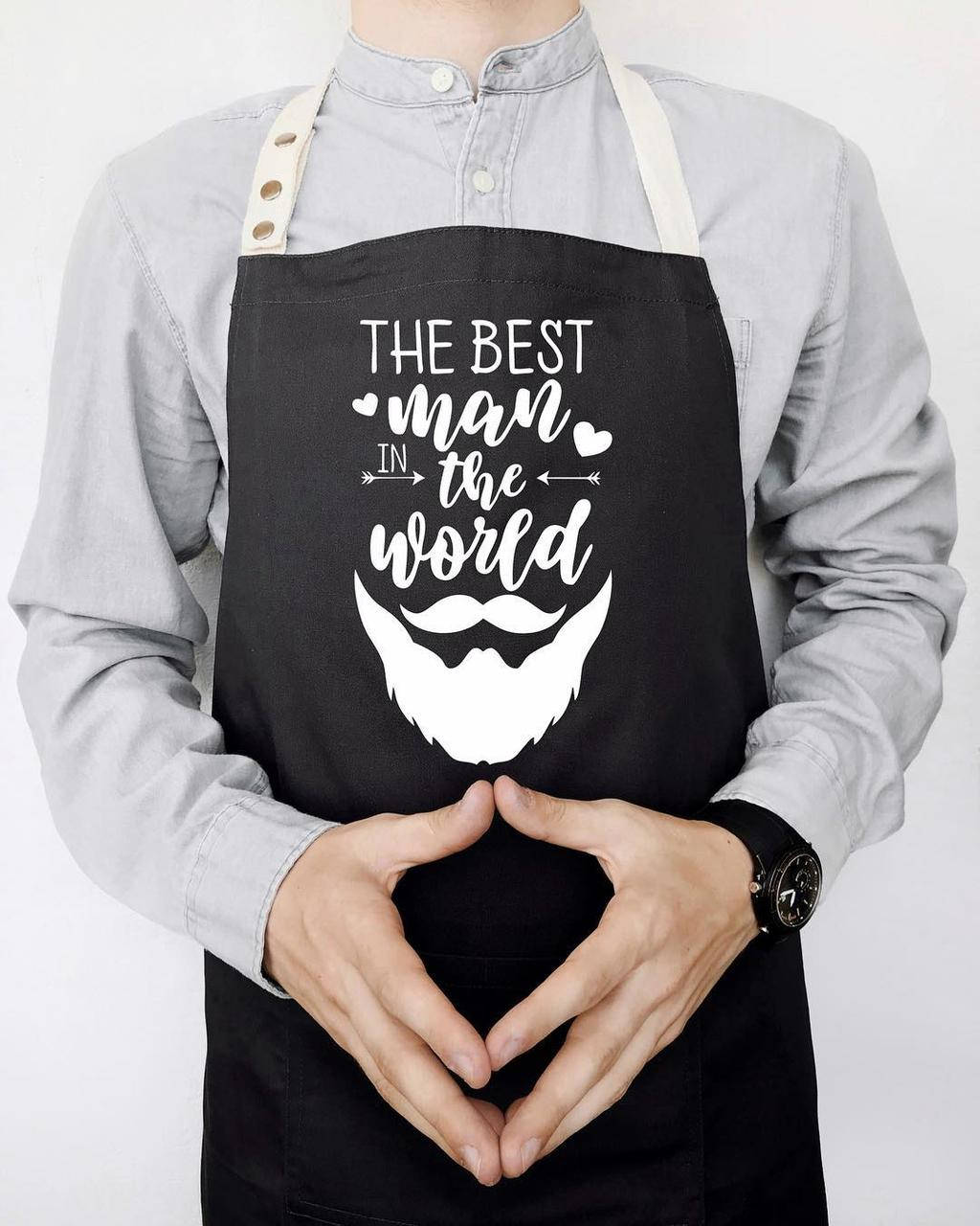 

Мужской фартук для кухни с прикольной надписью "The best man in the world" черный