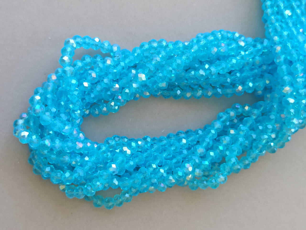 

Бусины хрустальные (Рондель) 4*3 мм, пачка 140-145 шт, цвет - голубой прозрачный с переливом