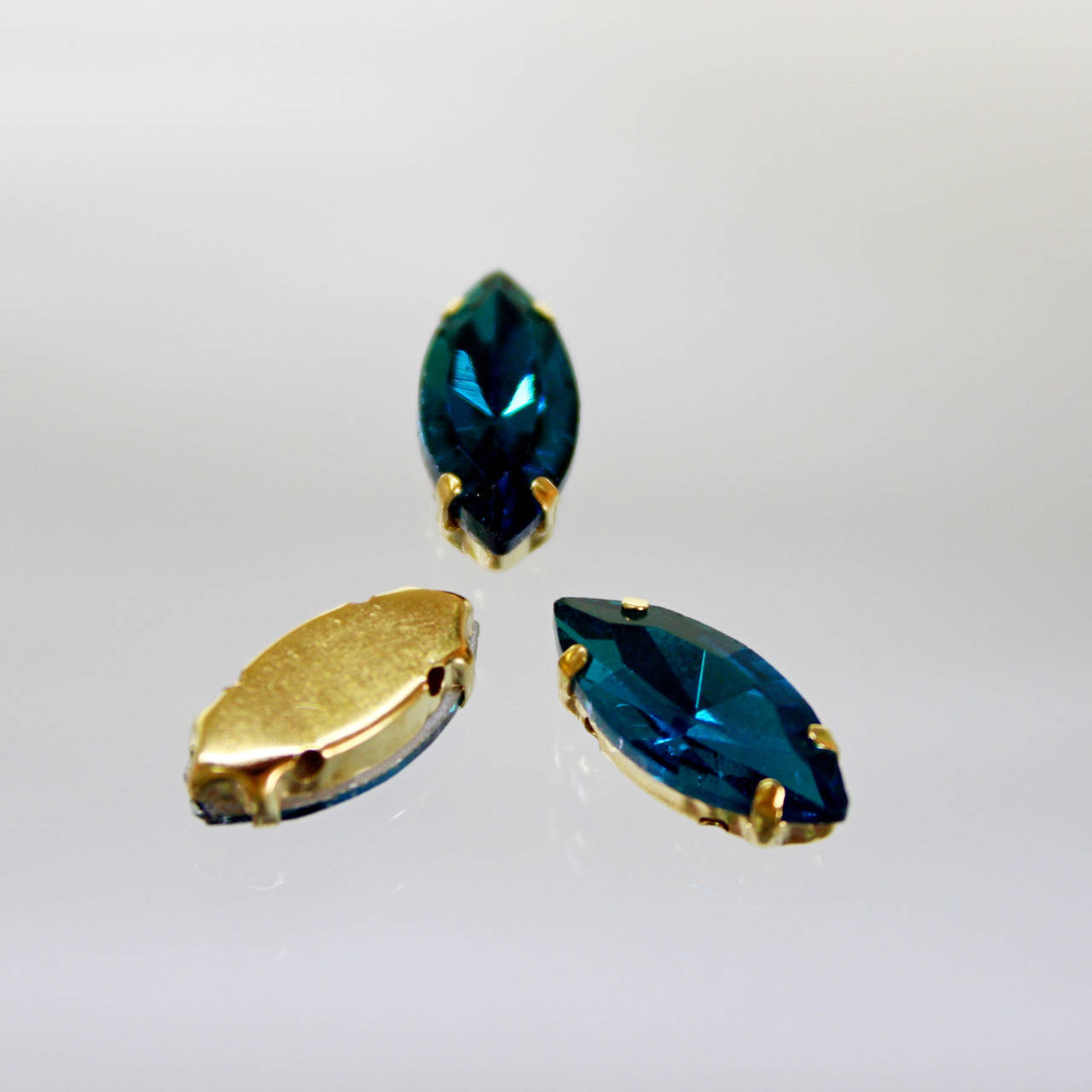 

Cтразы в золотых цапах.Лодочка 9х18мм.Цвет Blue Zircon, Белый