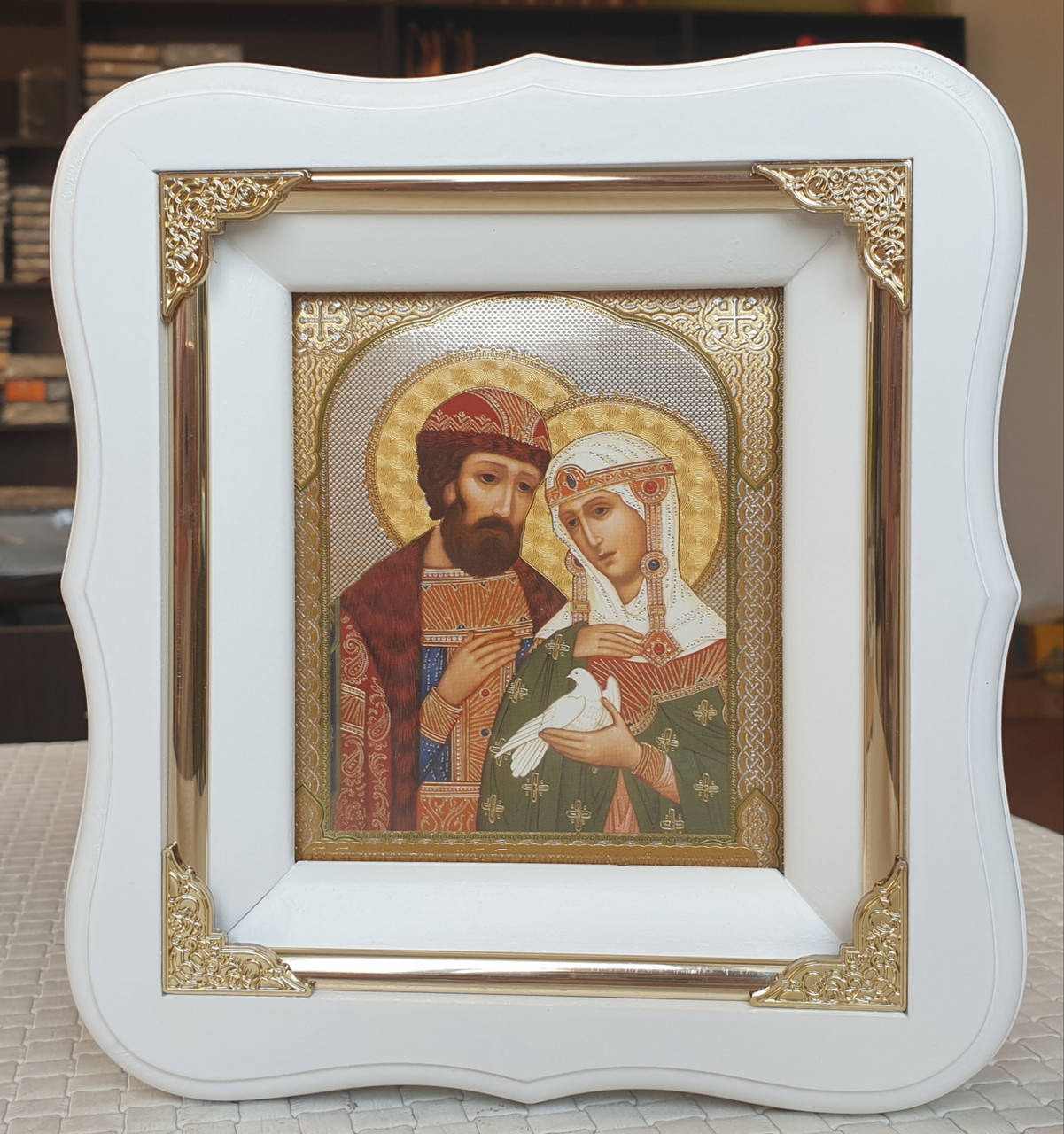 

Икона Петр и Феврония в белом фигурном киоте с декоративными уголками, размер киота 19×17, лик 10×12