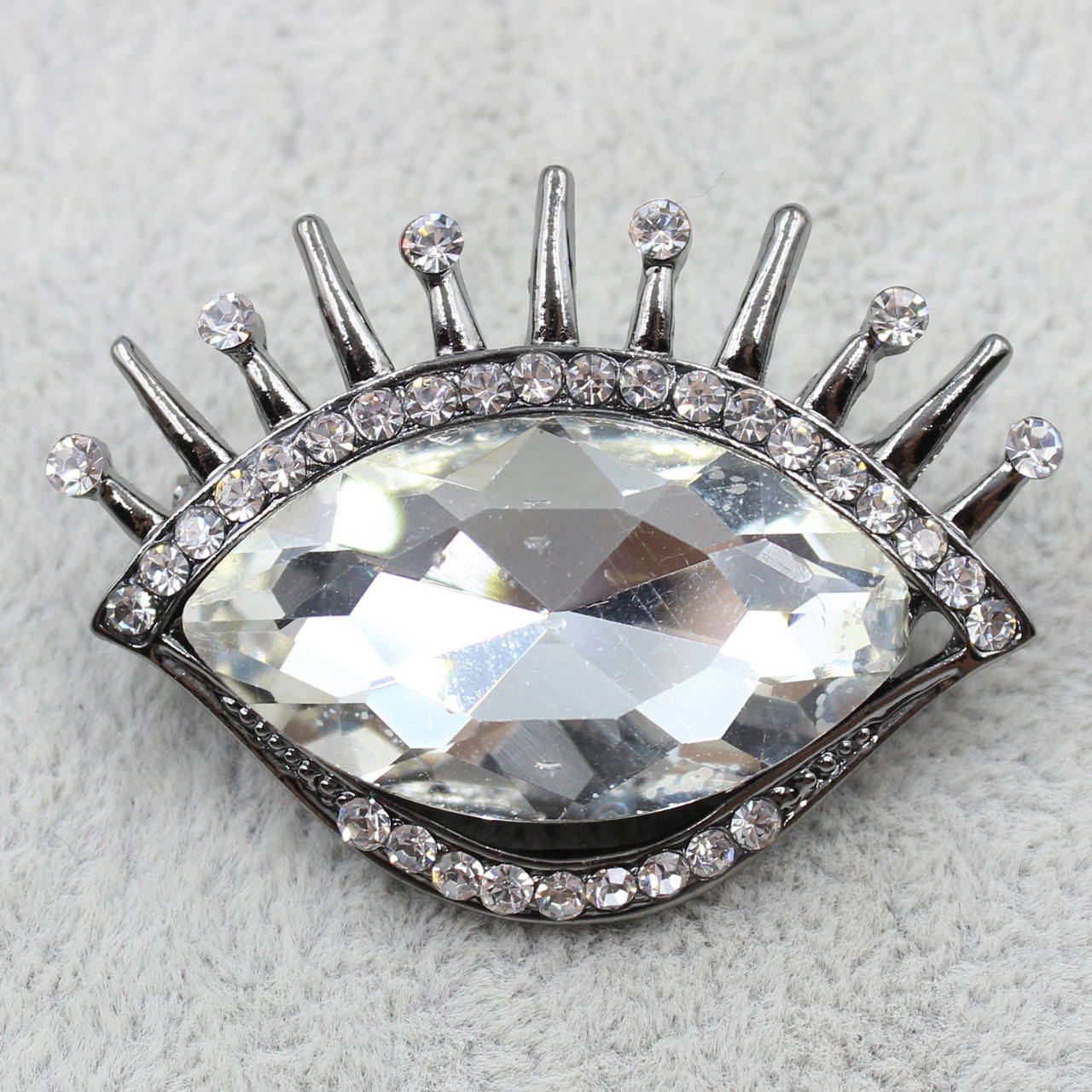 

Брошь металлическая серебристая Глаз с большм белым кристаллом размер изделия 40х33 мм