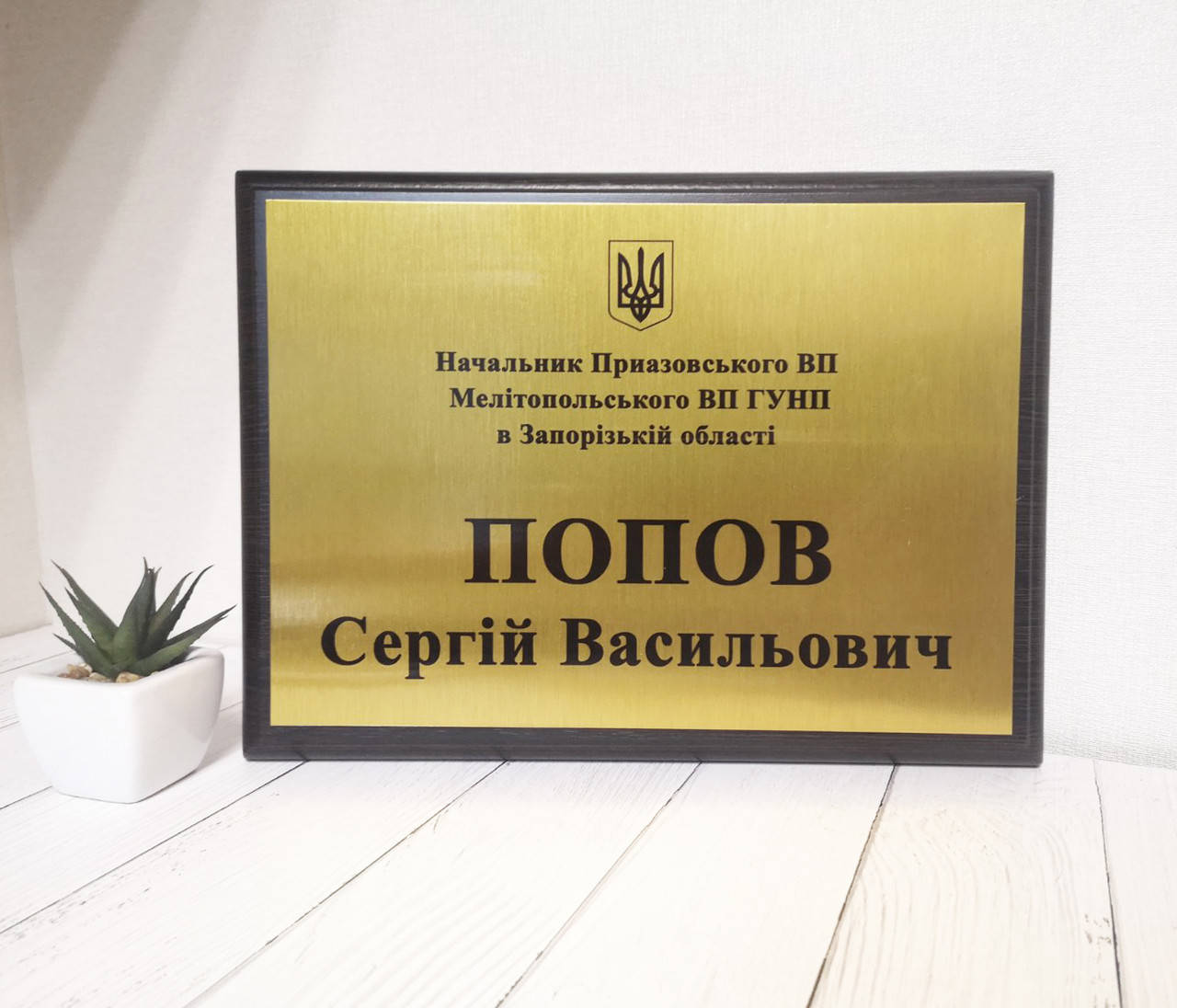 

Металлическая табличка на деревянной основе