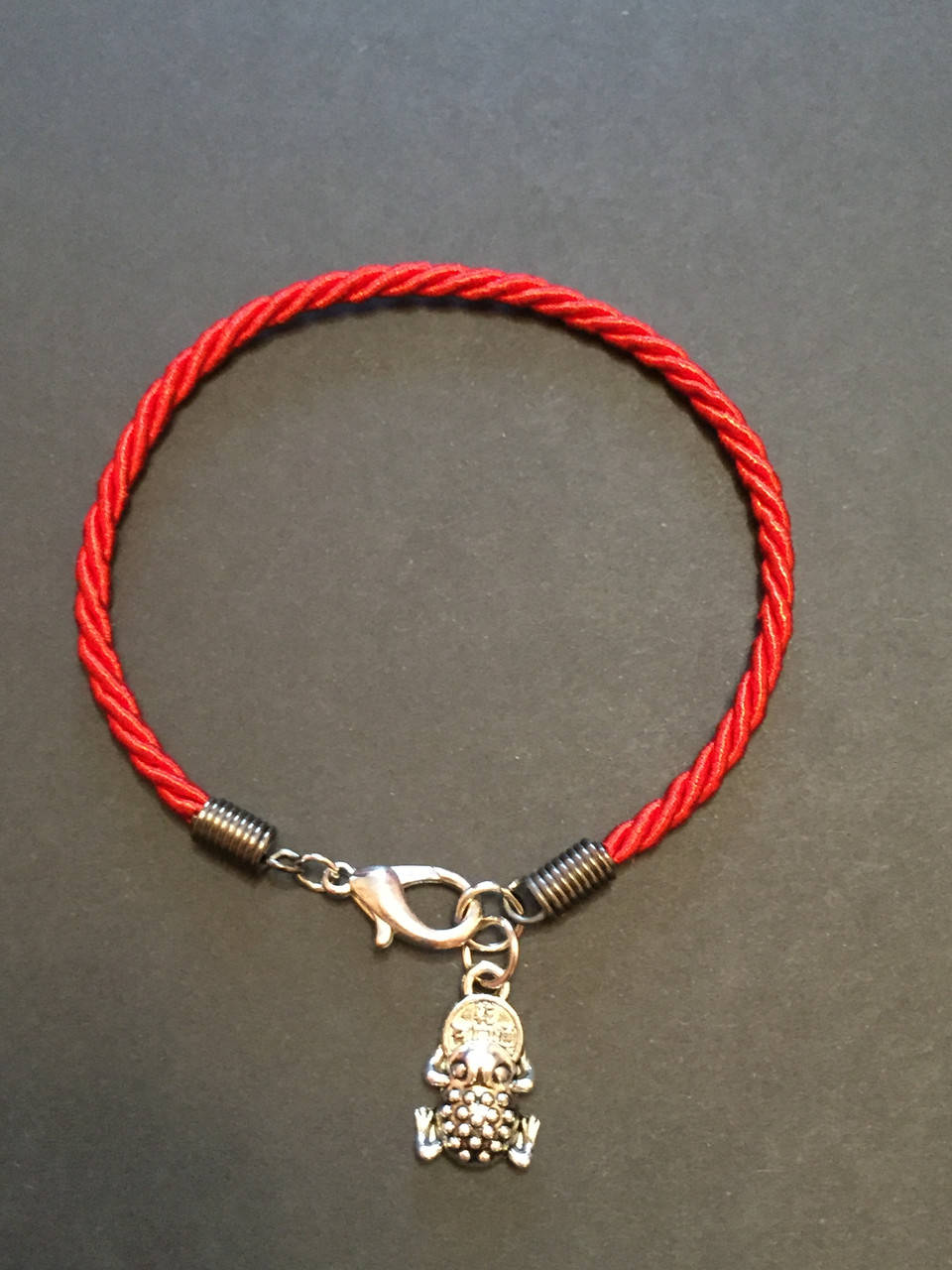 

Красная нить с талисманом Денежная лягушка