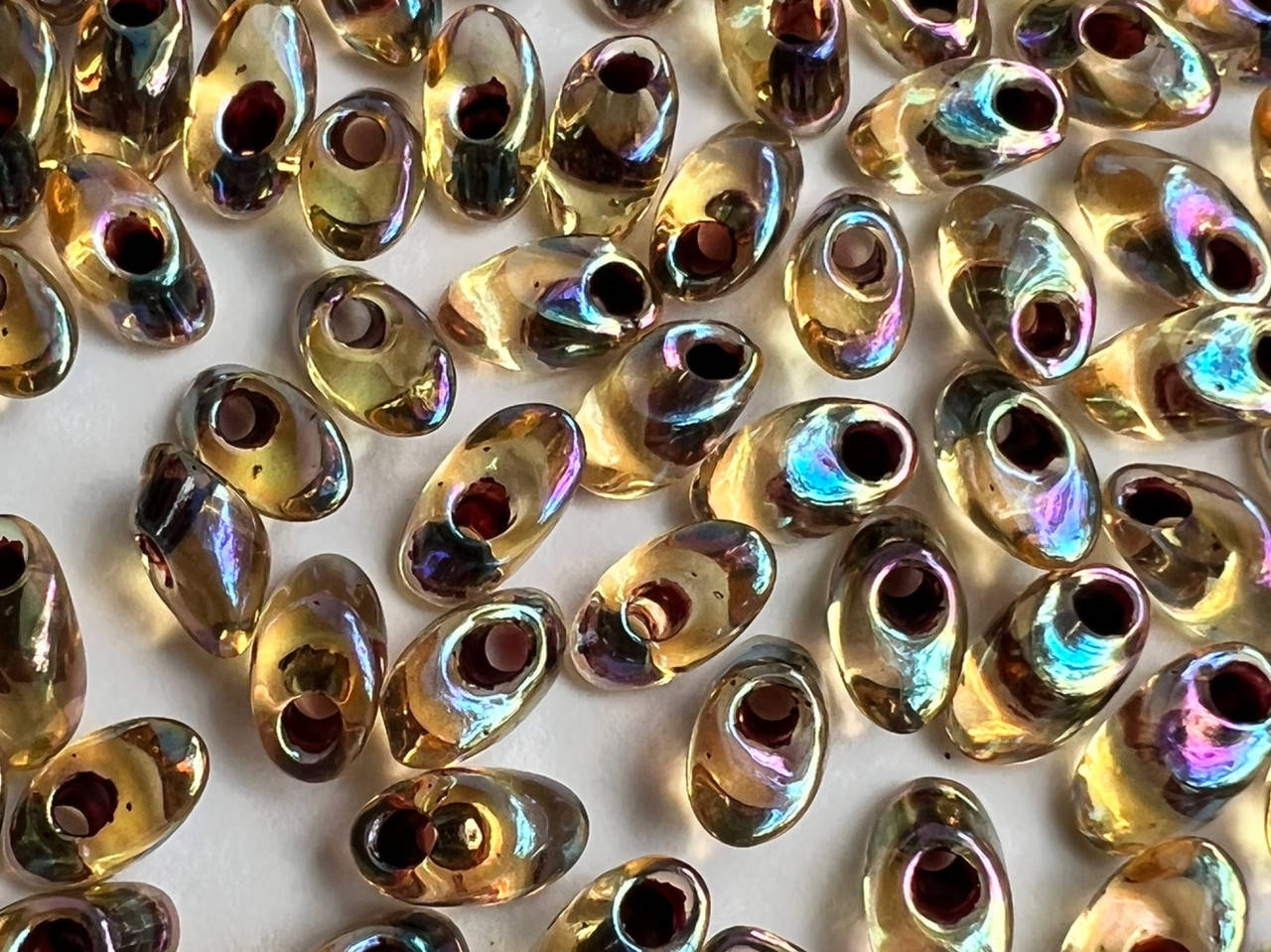 

Miyuki Long Magatama (LMA) 4 x 7 mm 2161 Garnet Lined Transp Lt.Topaz