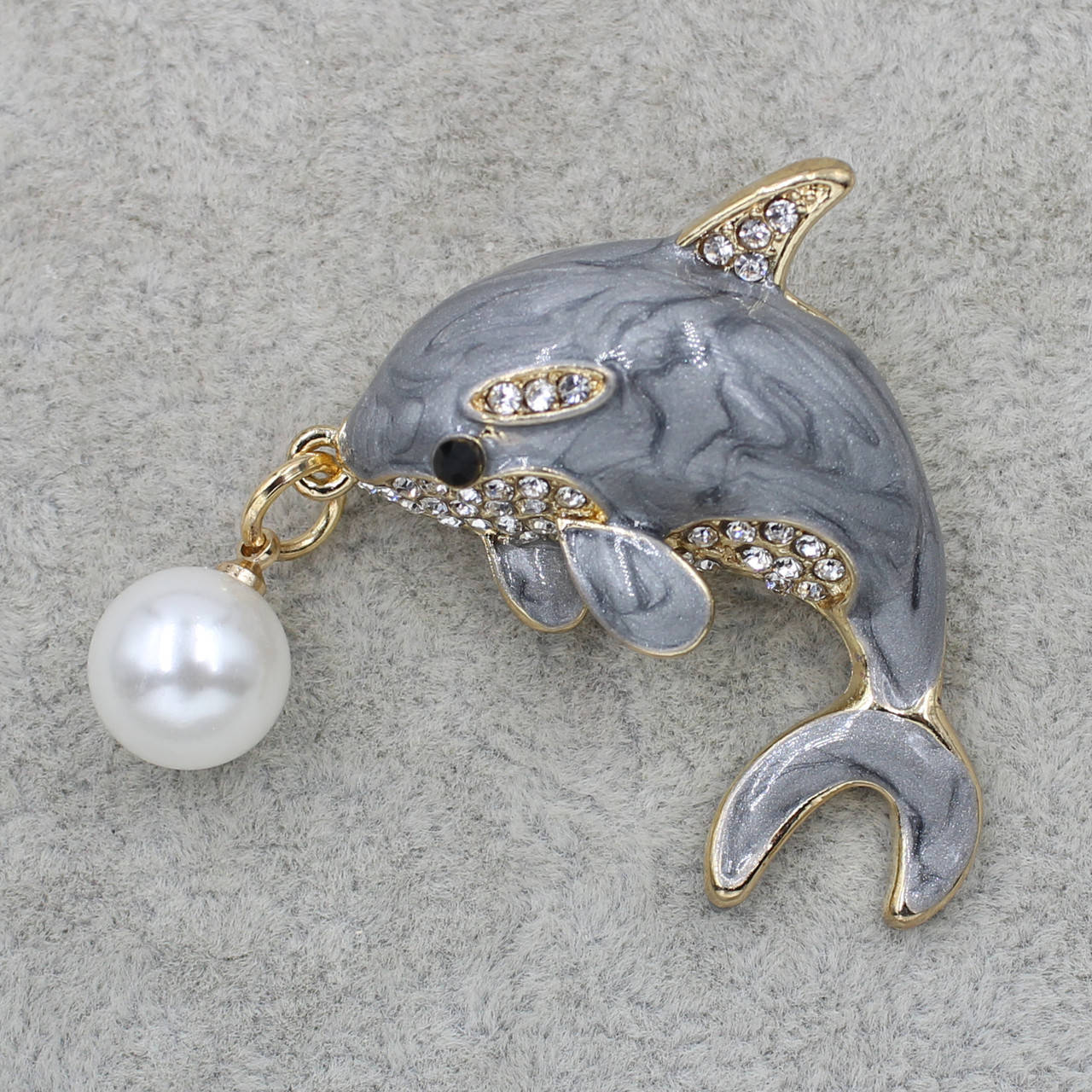 

Брошь металлическая золотистая Дельфин с жемчужиной в стразах покрыта цветной эмалью размер изделия 30х30 мм